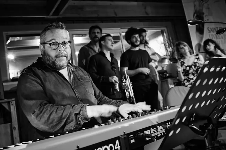 Keyboard player performing with the band, photographed in black and white — Jazz photography by Michaël Gramm
