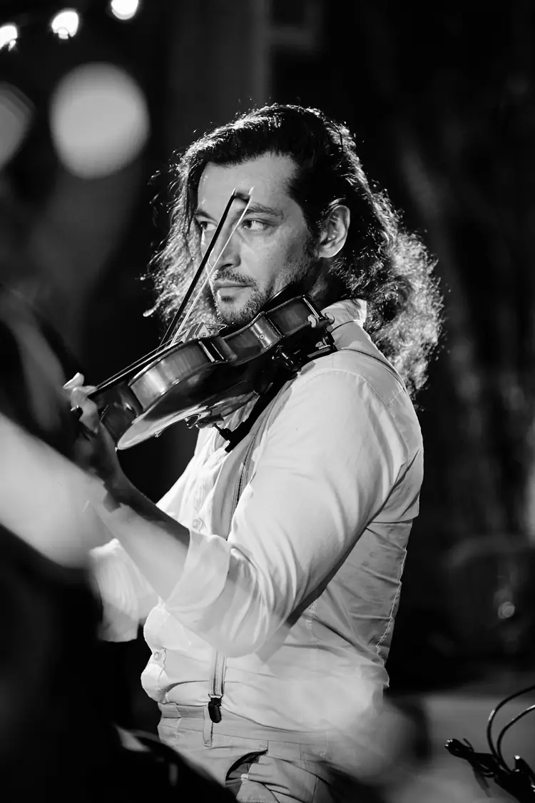 Violinist holding his bow beneath soft concert lights, photographed in black and white — Jazz photography by Michaël Gramm
