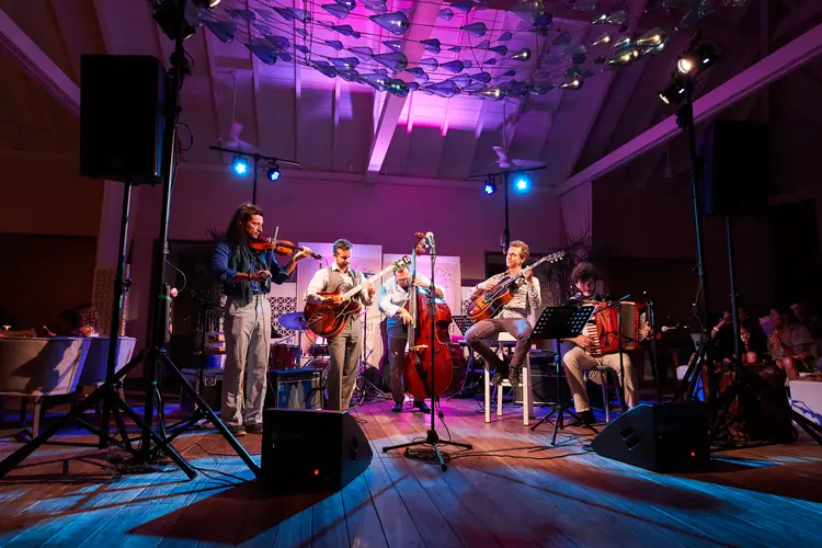 Jazz ensemble beneath a purple-lit ceiling on a wooden stage — Jazz photography by Michaël Gramm