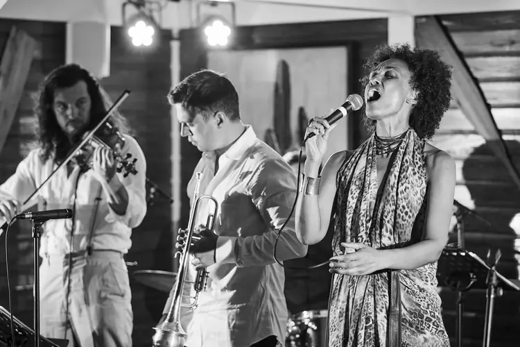 Musicians and singer sharing an energetic moment on stage, in black and white — Jazz photography by Michaël Gramm