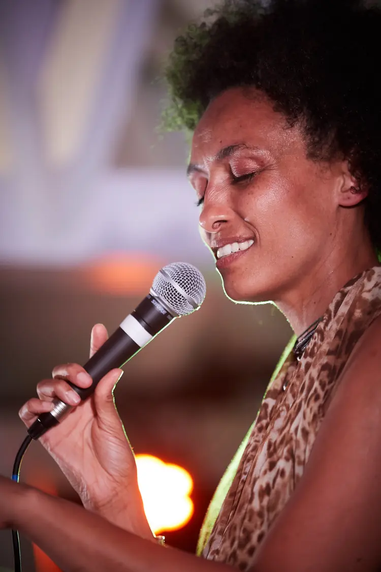Close portrait of a singer smiling with her eyes closed at the microphone — Jazz photography by Michaël Gramm